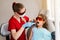 Child dentistry. Uv illumination of photopolymer tooth filling procedure. Child dentist in red protective glasses treats