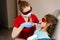 Child dentistry. Uv illumination of photopolymer tooth filling procedure. Child dentist in red protective glasses treats