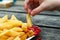 Child dipping a chip into tomato sauce