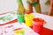 Child dipping fingers in non-toxic finger paints