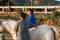 Child with disabilities having an equine therapy session assisted by an instructor.