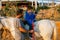 Child with disabilities having an equine therapy session with a physiotherapist.