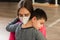 child with disabilities is hugged by physiotherapist wearing protective mask