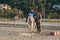 Child with disabilities riding a horse in an equine therapy session at an equestrian center.