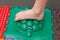 child does leg exercises on orthopedic massage mat at home. Puzzle mats imitating different textures for baby foot massage.