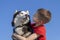 Child and dog look at each other. Boy hugged with love Siberian husky dog, isolated on blue. Friends together.