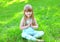 Child doing yoga exercises sitting on the grass