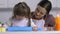 Child with down syndrome rolling out dough on table