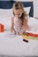 Child drawing on fathers day greeting card while sitting on bedding