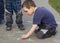 Child drawing on the pavement with chalk