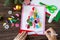 The child draws details Christmas tree greeting card.