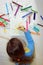 A child draws a flower pencil on a white sheet of paper, shows interest in drawing, view from above