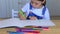 The child draws on paper with colored pencils at home insulation.