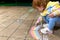 A child draws a rainbow with multi-colored crayons on a summer evening outside the premises