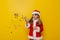 Child dressed as Santa throwing colorful confetti