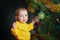 Child dresses up Christmas tree