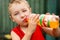 Child drinking unhealthy soda. Kid consuming sugar beverage