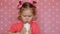 The child drinks a milk. A nice little girl holding a glass with drink in her hands and drinking.