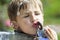 A child drinks water from a fountain.