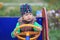 Child drives wooden car on the kindergarden playground