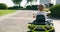 A child driving a toy electric car in a park on a summer day