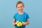 Child and Easter. Smiling blond boy, 6 years old, is holding a yellow eggs.