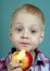 Child eating apple. little boy eating with appetite a big apple. healthy food for children