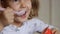 Child eating cottage cheese with a spoon. Baby girl eats dairy product yogurt. Portrait closeup.