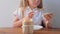 Child eating crispbread with peanut butter sitting at table home kitchen. School girl with bread slice wholegrain snack hard tack.