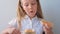 Child eating crispbread with peanut butter sitting at table home kitchen. School girl with bread slice wholegrain snack hard tack.