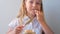 Child eating crispbread with peanut butter sitting at table home kitchen. School girl with bread slice wholegrain snack hard tack.