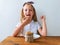 Child eating crispbread peanut butter sitting at table in kitchen at home. Nutritious superfood vegan healthy lifestyle