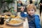 Child, eating japanese sushi and noodles with chopsticks in a restaurant