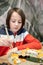 Child, eating japanese sushi and noodles with chopsticks in a restaurant