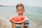 Child eating juicy watermelon. Kids emotions boy eating watermelon on the background of the sea, the beach, the sea coast