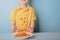 Child eating spaghetti with his hands. concept of dirty stains on clothes. isolated on blue background