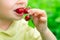 The child eats a cherry. Summer berries. Vitamins for children. Healthy food.