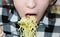 A child eats Chinese instant noodles with a fork