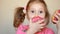 Child eats donut. Closeup baby girl eating doughnut with glase. Delicious, sweet, sweettooth