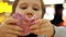 Child eats donut. Closeup baby girl eating doughnut with glaze. Delicious, sweet, sweet tooth