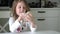 A child eats honey with a spoon from a plastic jar