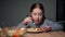 The child eats pasta with a fresh salad of tomato, pepper and round cheese