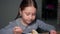 The child eats pasta with a fresh salad of tomato, pepper and round cheese