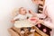 The child eats puree from a spoon sitting at a feeding chair in the children`s room