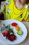 The child eats from a white plate scrambled eggs with sausage, vegetables and herbs. Scrambled eggs prepared in the form of