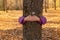 Child embracing tree trunk