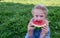 The child enjoys eating delicious, red, ripe, juicy, appetizing watermelon.