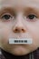 Child face with barcode sticker on mouth. Individual identifier.