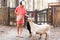 A child feeds two goats from a paper bag at a zoo or farm. Pet therapy.