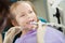 Child feels toothache during polishing procedure in dentist chair